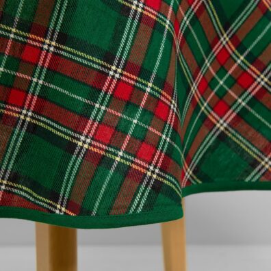 Žalia apvali (ovali) staltiesė su raudonais, baltais, juodais ir geltonais langeliais