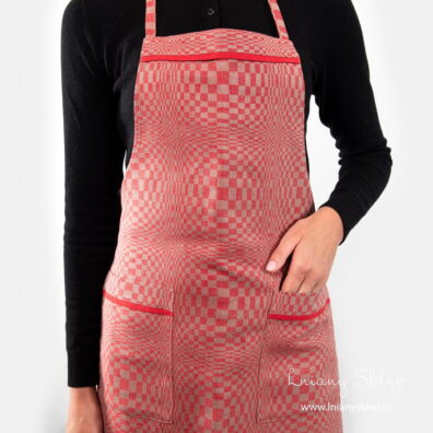 Kieszenie i górę fartucha zdobi czerwona lamówka.