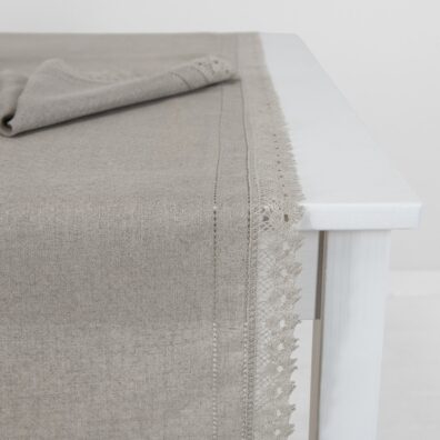 Szary bieżnik stołowy ozdobiony mereżką i koronką