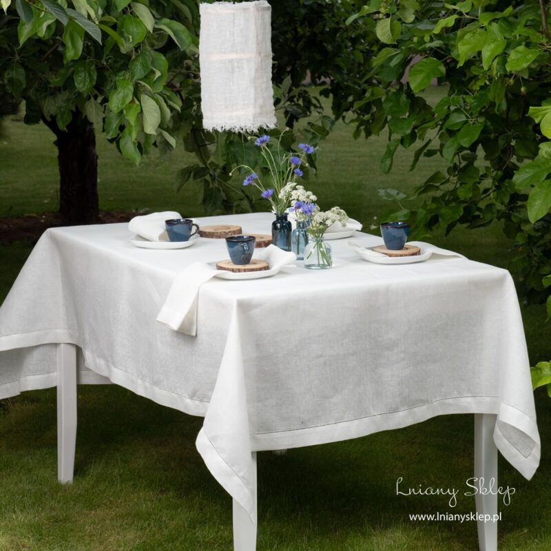 Lniany biały ażurowy obrus ozdobiony mereżką.