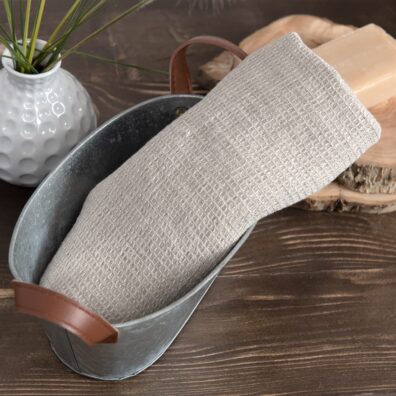 Przytulny, szary - o barwie naturalnego włókna lnianego - ręcznik z pranej, wytkanej we wzór waflow, tkaniny