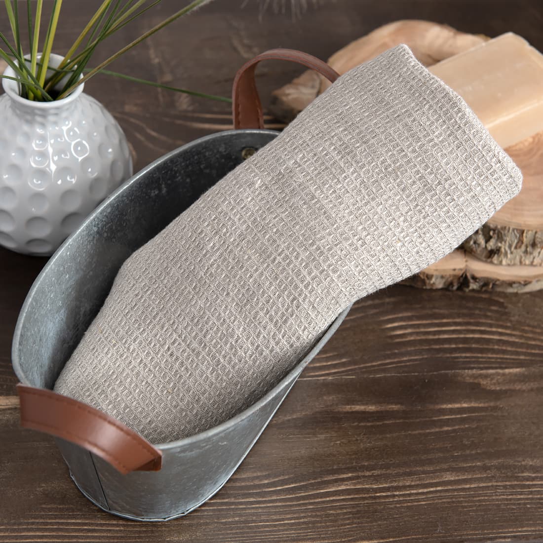 Przytulny, szary - o barwie naturalnego włókna lnianego - ręcznik z pranej, wytkanej we wzór waflow, tkaniny