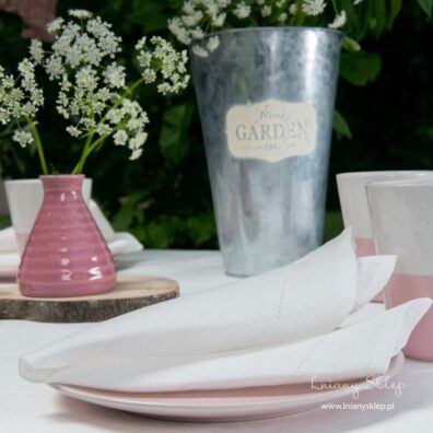 Duża mlecznobiała serwetka stołowa wykończona mereżką.