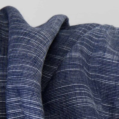 Melanżowa tkanina lniano - bawełniana wytkana z gładkiej ciemnoniebieskiej i dekoracyjnej białej bawełnianej przędzy.