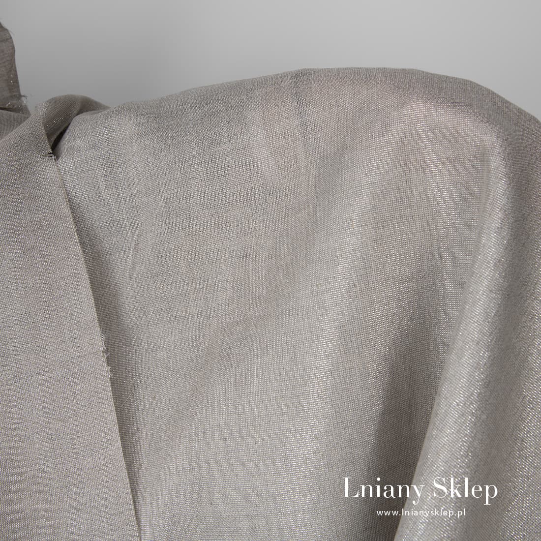 Szara tkanina z przędzy lnianej oraz lureksowej.