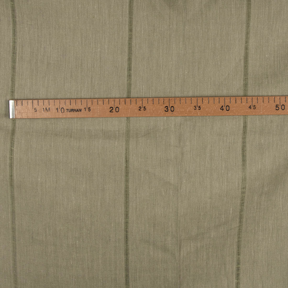 Lniana tkanina zielona w prześwitujące paski.