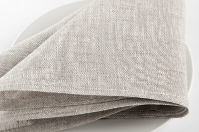 Lniana jasna szara serwetka bankietowa. Brzeg wykończono gładkim szwem.