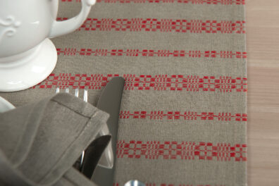 Lniano-bawełniany bieżnik stołowy w czerwone ornamenty.