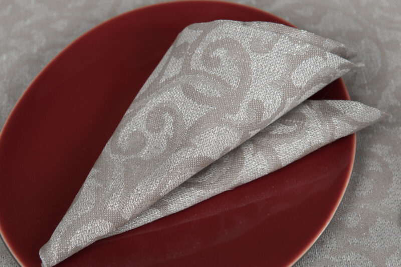 Lniana serwetka stołowa w srebrzysto &ndash; szary ornament.