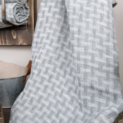 Ręcznik z pranej tkaniny lnianej ozdobionej geometrycznym wzorem.