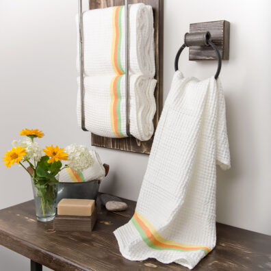 Biały ręcznik ozdobiony kolorowym pasem.