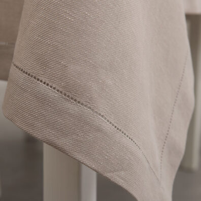 Różowy o szarym odcieniu obrus z mereżką.