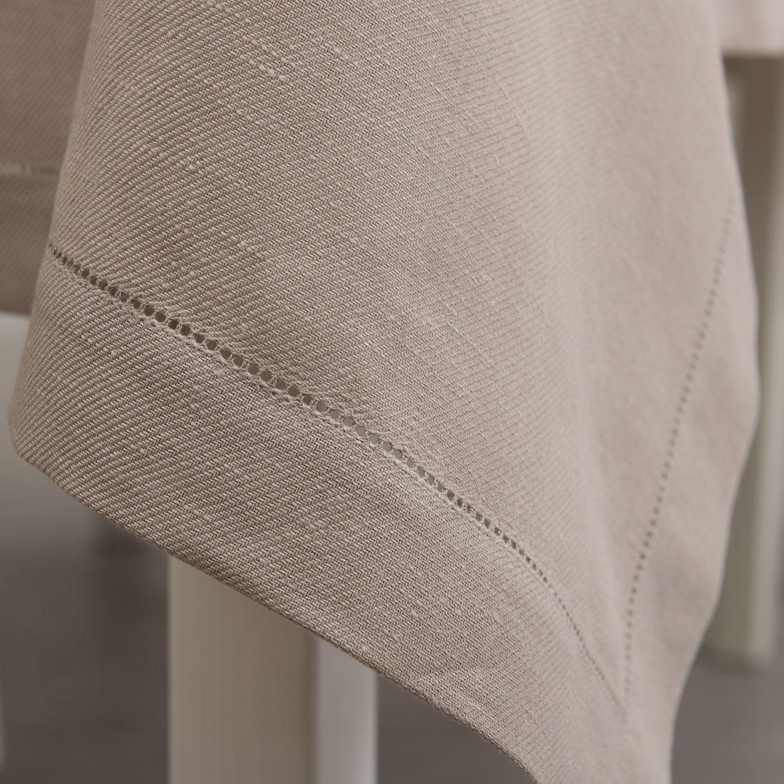 Różowy o szarym odcieniu obrus z mereżką.