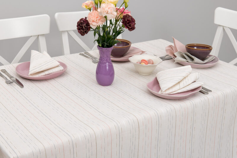 Mlecznobiały obrus w pastelowe paski.