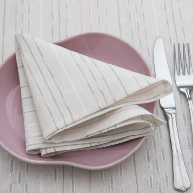 Mlecznobiała serwetka w pastelowe paski.