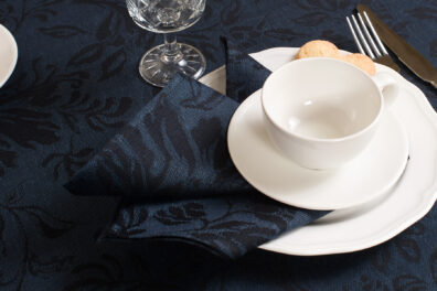 Na granatowym tle wytkano czarne piękne kwiaty.