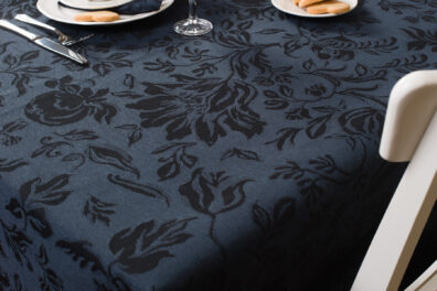 Granatowe tło wytkane w czarne kwiaty.