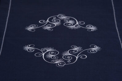 Granatowy bieżnik ozdobiony białym haftem.