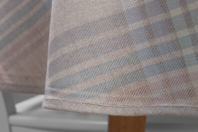 Brzeg obrusu wykończono szarą lamówką.