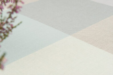 Obrus lniany w dużą szaro - zielono - różową kratkę.