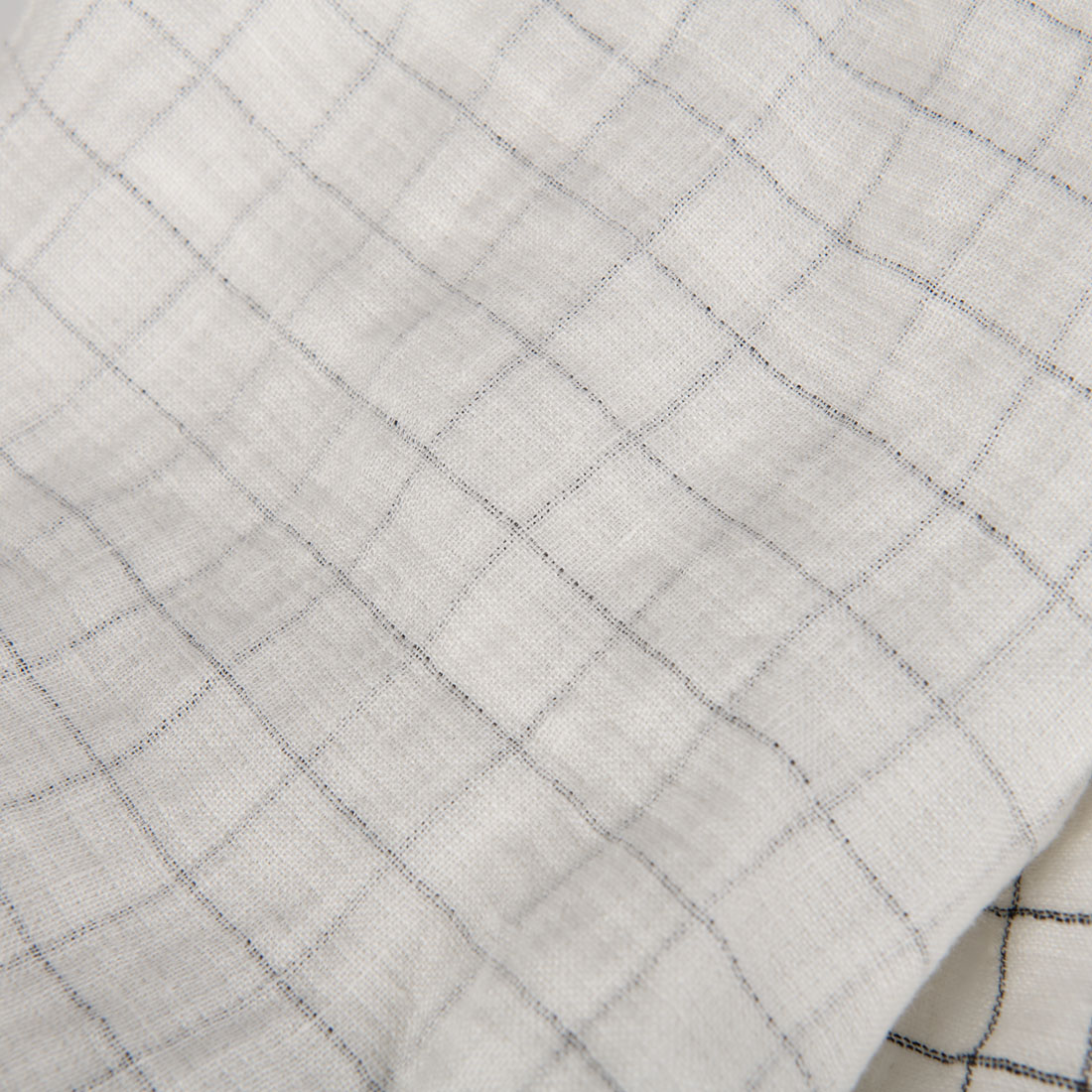 Jedna strona tkaniny - w bladą, czarną kratkę