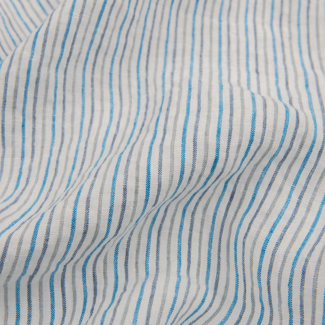 Prana biała tkanina w niebieskie i granatowe paski.