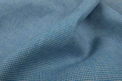 Tkanina lniana w drobną niebieską krateczkę.