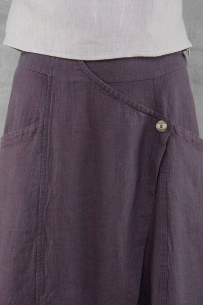 Spódnicę zdobi szeroka zakładka zapięta na guzik.