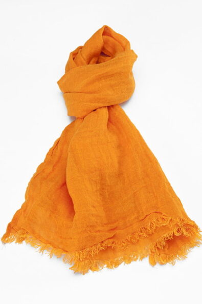 Cieniutki pomarańczowy lniany szalik wykończony strzępionymi brzegami.
