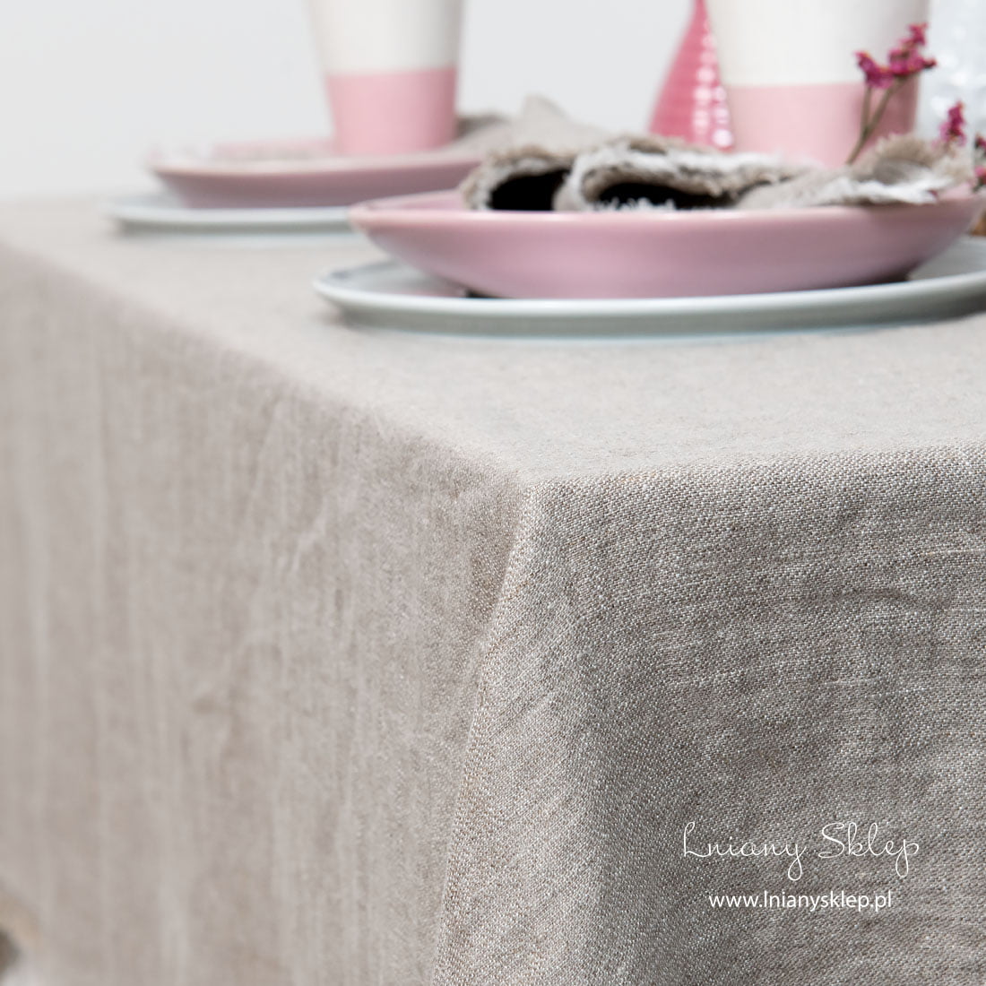 Jasnoszary z frędzelkami obrus. Lekko gnieciona faktura.