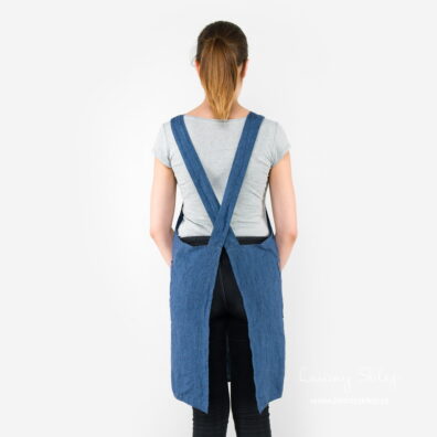Lniany niebieski fartuch. Szelki skrzyżowane na plecach.