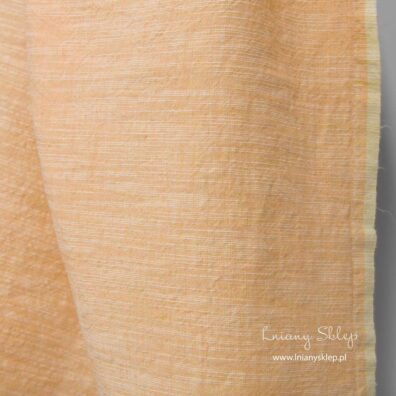 Szeroka, prana tkanina lniano – bawełniana brzoskwiniowa w poziome, nieregularne, białe paski.