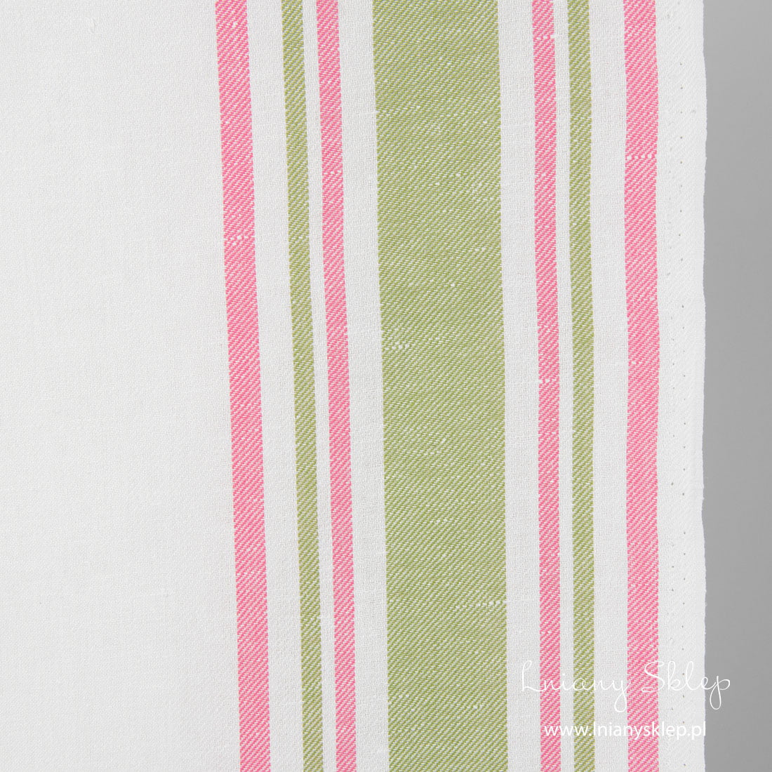 Biała tkanina w paski różówe i zielone na brzegach.