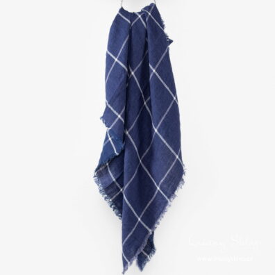 Granatowa lniana chusta w cienką, białą kratkę.