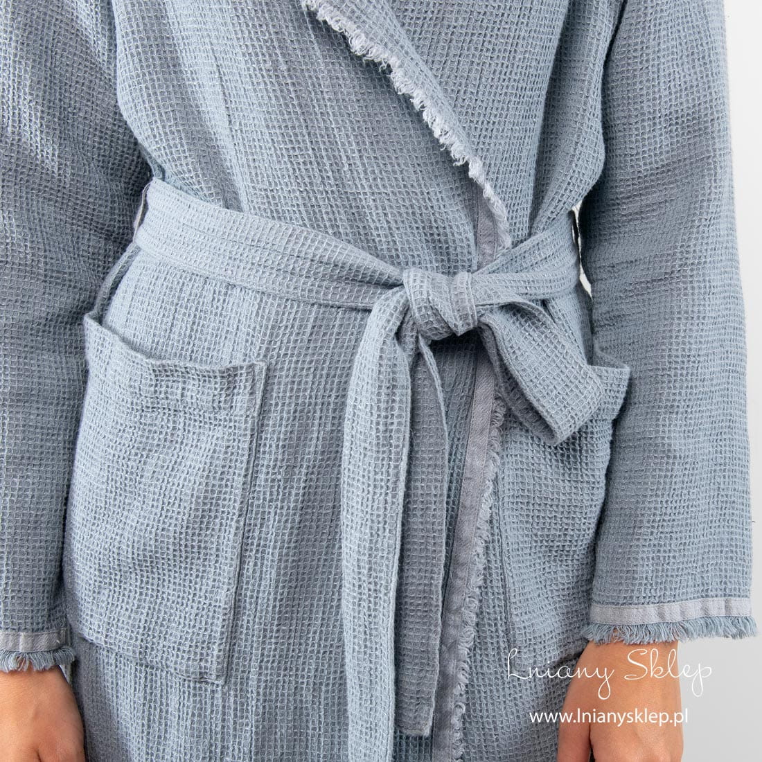 Niebieski damski szlafrok obszyty gładką tasiemką. Ozdobiony frędzelkami.