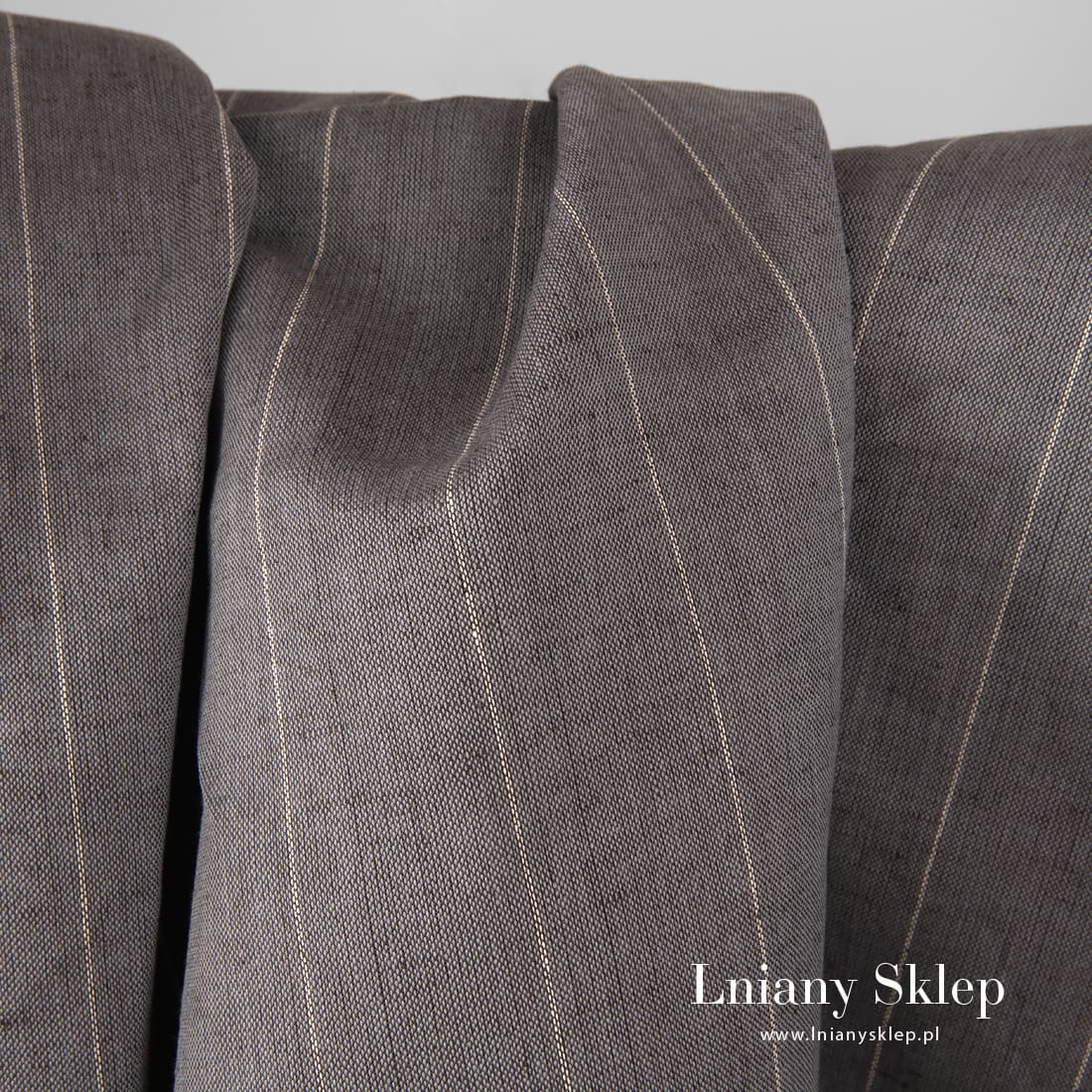 Szeroka szara ciemna tkanina w paski mlecznobiałe.