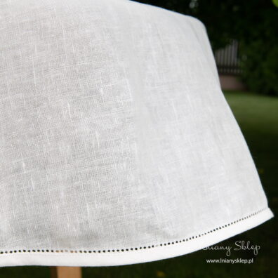 Mlecznobiały lniany obrus ozdobiony mereżką.