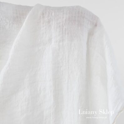 Biała tkanina w ażurowe przeźroczyste okienka.