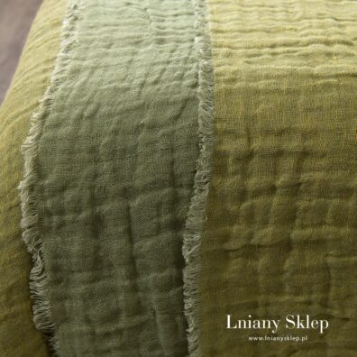 Dwustronna zielono - żółtawa narzuta na łóżko.