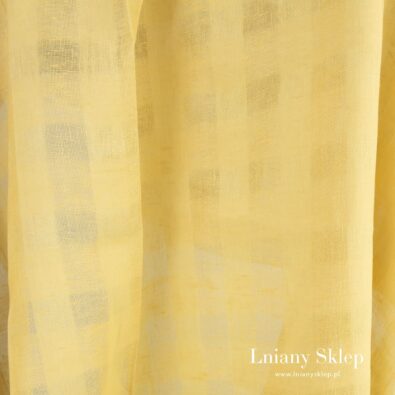 Żółta lniana tkanina w ażurowe okienka.