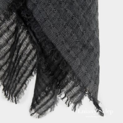 Szara chusta ozdobiona strzępionymi frędzelkami.