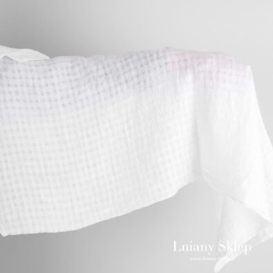 Biała tkanina lniana w przeźroczystą kratkę prana.