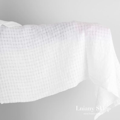 Biała tkanina lniana w przeźroczystą kratkę prana.