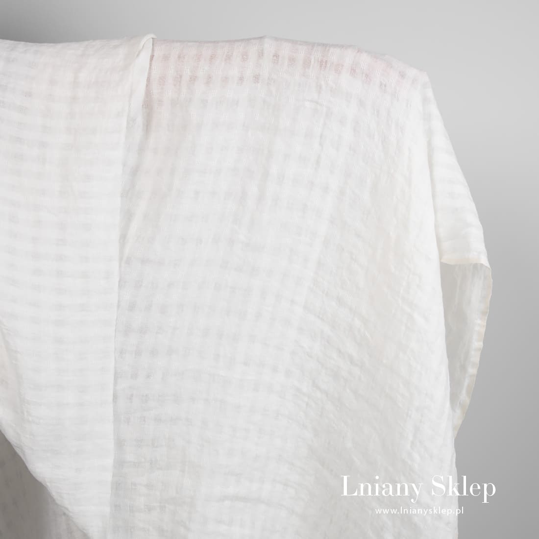 Biały len prany w prześwitującą kratkę.