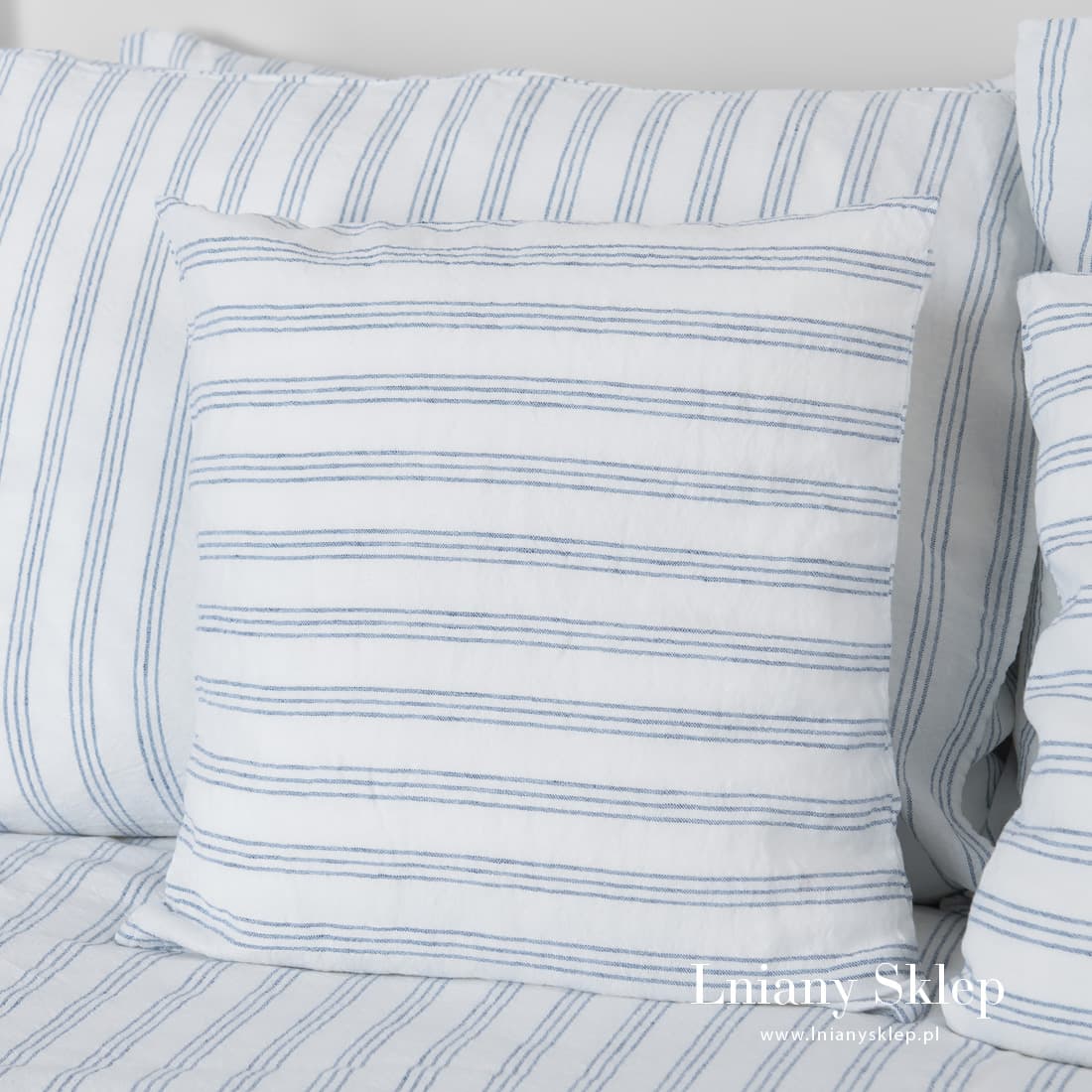 Białe w niebieskie paski poszewki na poduszki.