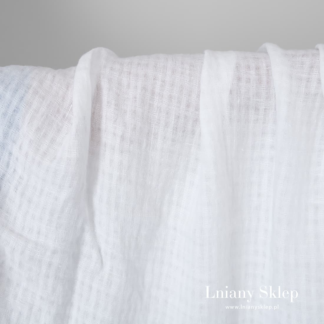 Śnieżnobiały prany len w prześwitującą krateczkę.