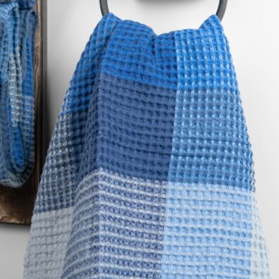 Ręcznik waflowy wytkany w niebieską kratkę.