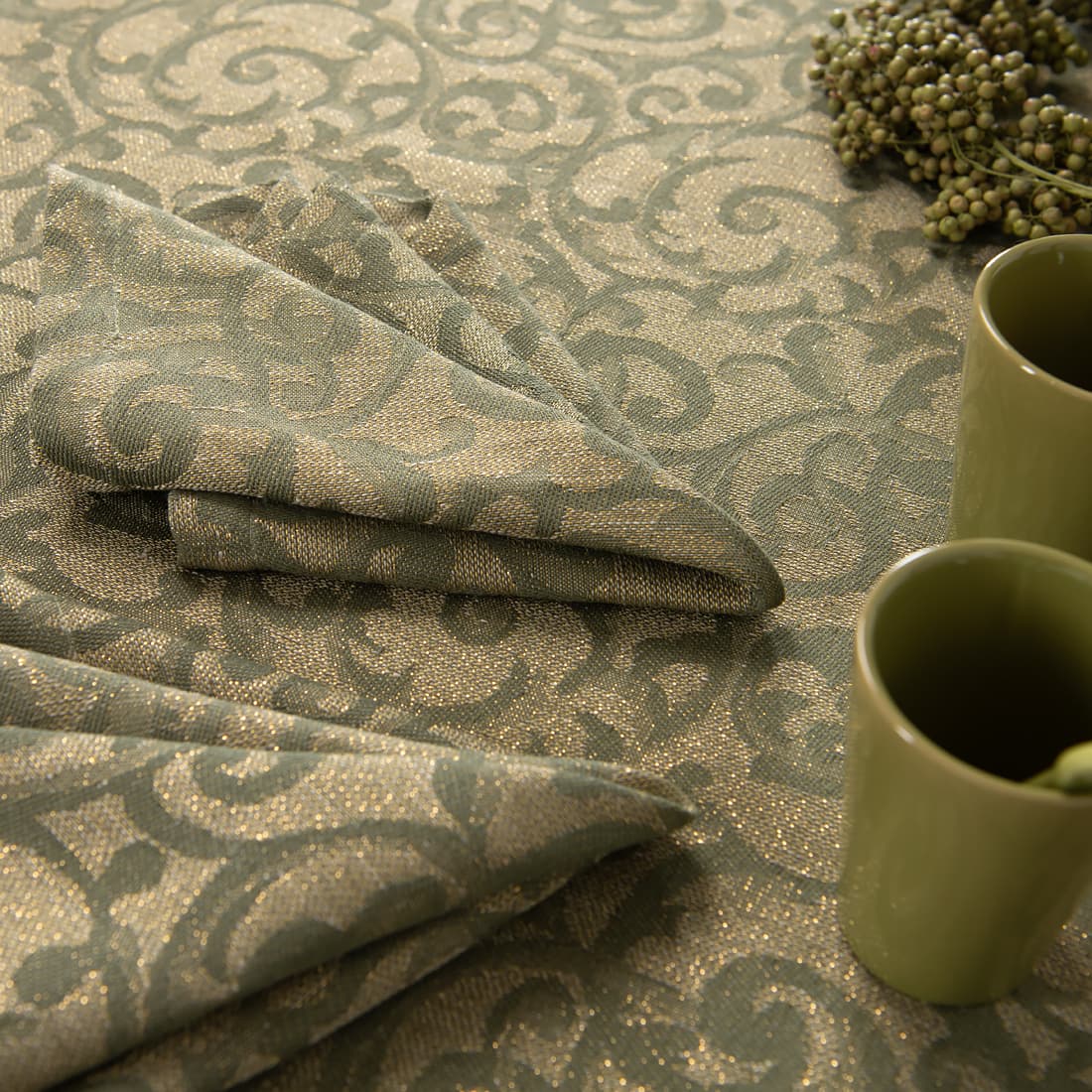 Zielony ze złotem żakardowy obrus i dopasowane serwetki.