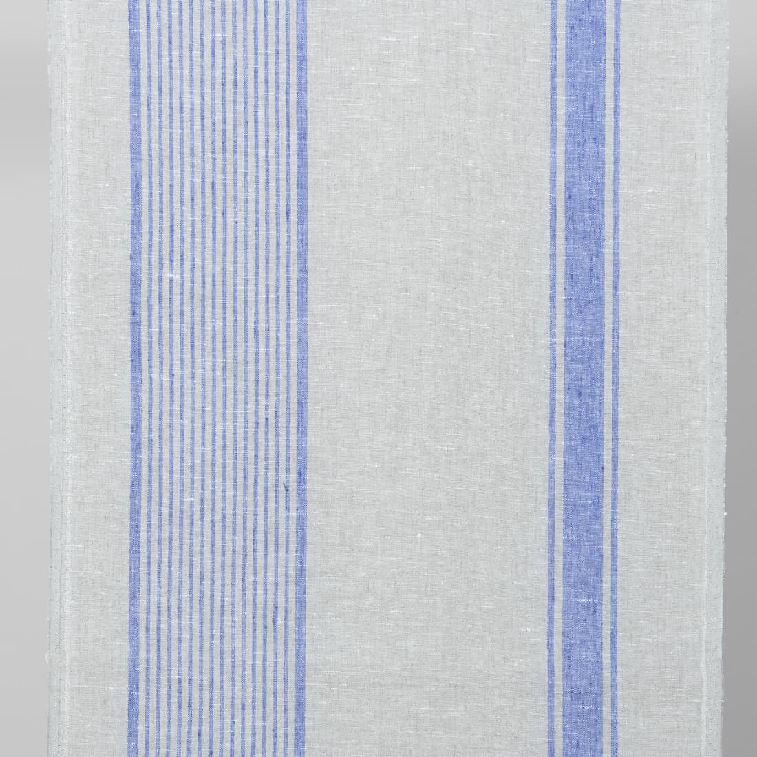 Szara tkanina ścierkowa w paski niebieskie.