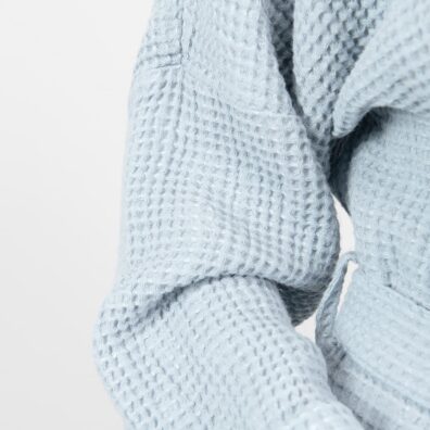 Jasny niebieskawy szlafrok z pranej tkaniny wytkanej splotem waflowym.